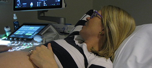 A physician inspects a sonogram